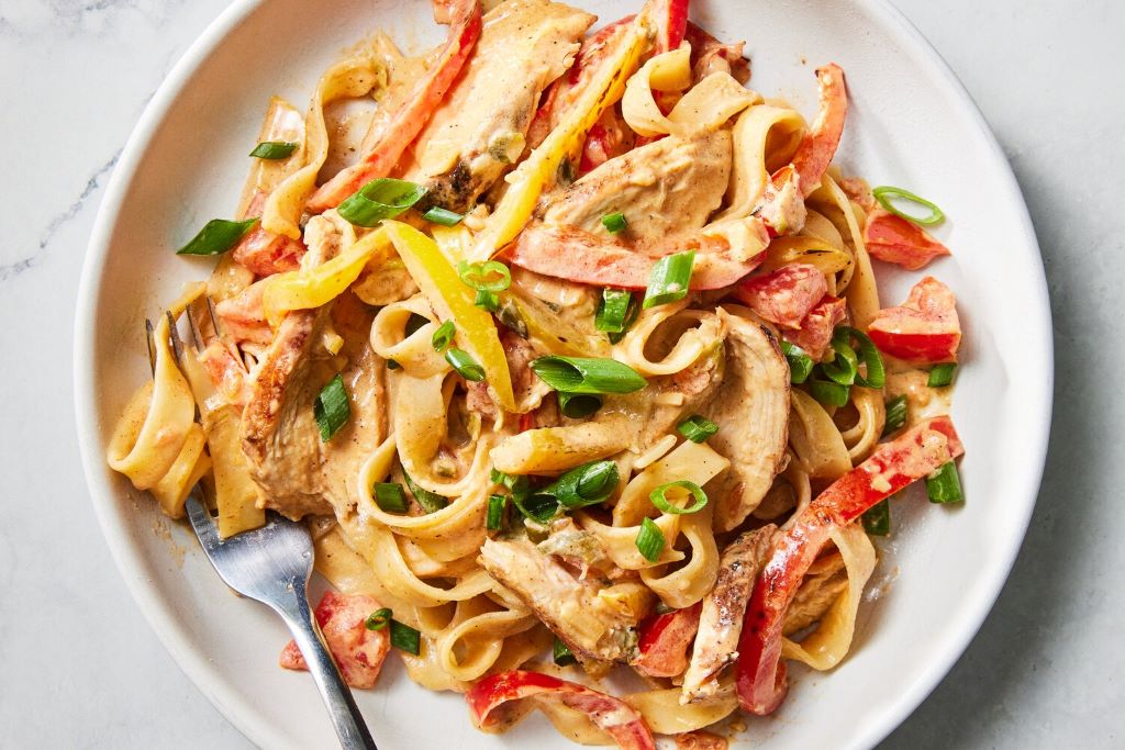 Close-up of spicy Cajun Alfredo sauce served over fettuccine noodles with a rich, creamy texture