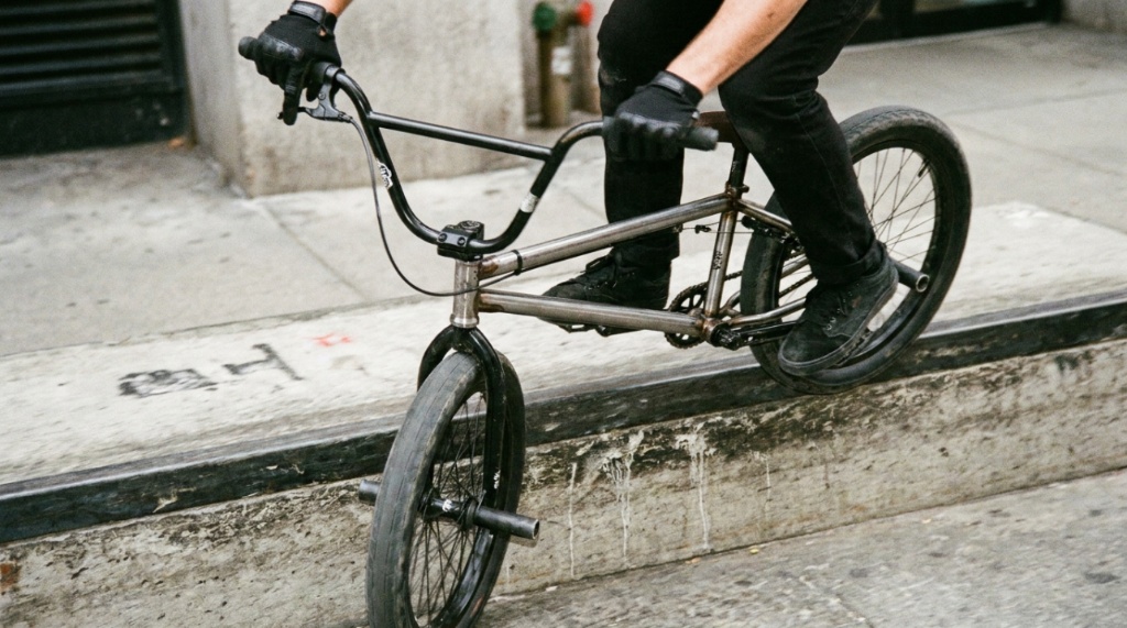 A BMX street rider catching air while gripping soft rubber grips.