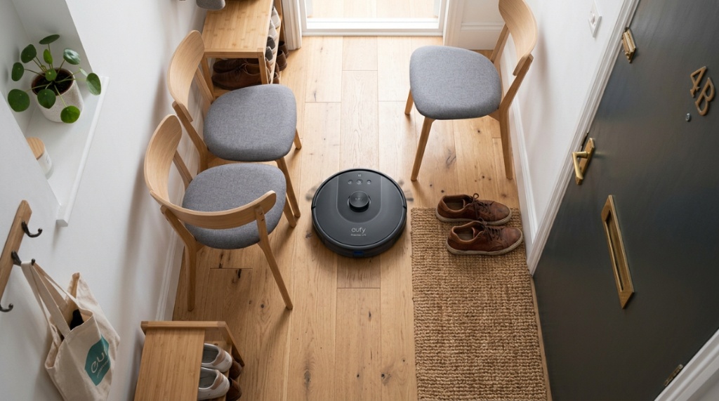 Robot vacuum cleans under a couch in a New York studio apartment.